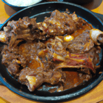 Galbi Jjim è fatto con costolette di manzo con osso, cipolla, carote, peperone verde, pepe nero, sale, salsa di soia, mirin, zucchero e olio di sesamo. Galbi Jjim è un piatto tradizionale del Natale coreano. È spesso servito con altri piatti natalizi coreani, come il Tteokguk (zuppa di riso con polpette di carne) e il Manduguk (zuppa di manzo con gnocchi). Il Galbi Jjim è un piatto versatile che può essere personalizzato in base ai tuoi gusti. Puoi aggiungere altri ingredienti alla marinata, come miele, pasta di zenzero o aglio. Puoi anche sostituire le costolette di manzo con altri tipi di carne, come il pollo o il maiale.